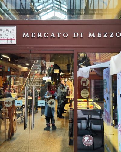 Ambiente animado en el Mercado di Mezzo de Bolonia en un día.